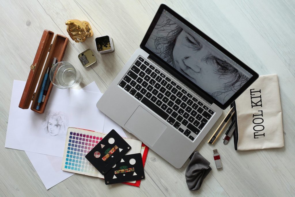 The most important element of graphic design in marketing is natural talent. This image depicts a laptop with a black and white image of a pencil sketch of a face.