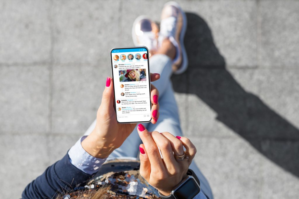 How much you spend on paid ads and how often you post on your social media channels isn’t as important as how effective these efforts are in converting prospects into customers, as represented by this image of a woman's phone as she communicates on social media.